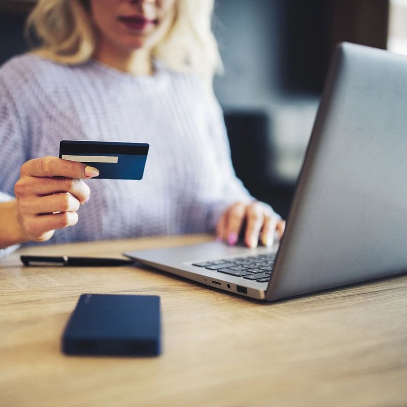 Woman with card and searching on laptop - Freedom Carpeting & Countertop in Wisconsin Rapids, WI